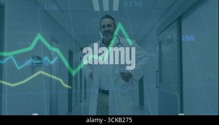 Stehender reifer Arzt, der Liniendiagrammüberlagerung im Krankenhauskorridor überprüft, mit Laborkittel Stockfoto