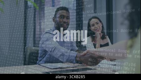 Mann in blauem Hemd, der im Konferenzraum die Hände schüttelt, mit Laptop-Topf-Netzwerk-Code-Overlay Stockfoto