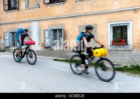 Touristen auf einer Rad- und Radtour durch Slowenien, erkunden die wunderschöne Berglandschaft in der Region gorenjska, vorbei an einem alten Bauernhof Stockfoto