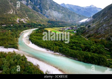 Kristallklarer türkiser Soča-Fluss, der durch die Julischen Alpen in Slowenien fließt, umgeben von dramatischen Bergen und unberührter Alpenlandschaft. Stockfoto