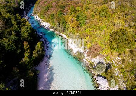 Kristallklarer türkiser Soča-Fluss, der durch die Julischen Alpen in Slowenien fließt, umgeben von dramatischen Bergen und unberührter Alpenlandschaft. Stockfoto