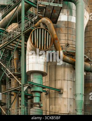 Industrieturm Rostrohre Grunge Textur Poster Struktur. Massiver Metallzylinder mit korrodierten Lüftungsschlitzen, oxidierten Rohren und verwittertem Stahl Stockfoto