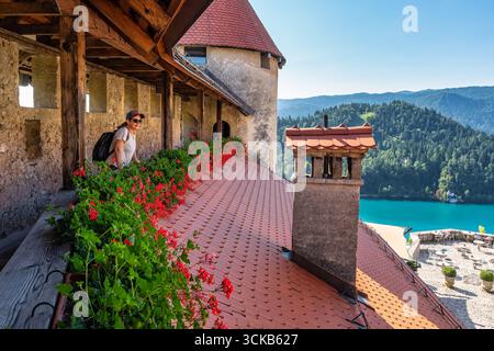 Touristen Frau, die die atemberaubende Aussicht auf den Bleder See von der Burg aus genießt, Slowenien. Stockfoto