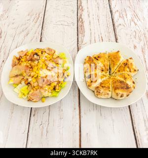 Russischer Salat mit gebratenem Hähnchen mit Kartoffeln, Mais und Sellerie, garniert mit Curry-Mayonnaise und Rosinen Stockfoto