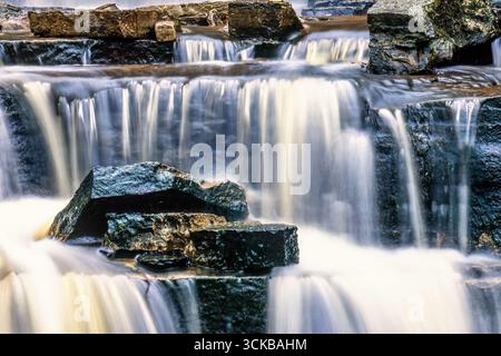 Fließendes Wasser über die Felsen in einem Bach Stockfoto