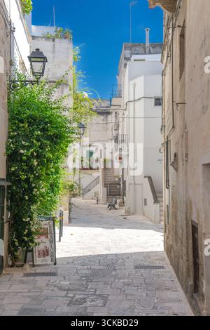 Ein Bild von Gebäuden zwischen Steingassen und mediterranen Balkonen im historischen Zentrum unter blauem Himmel, Süditalien. Grottaglie (Apulien, Italien) Stockfoto