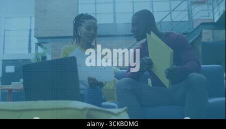 Zwei Kollegen, die Dokumente und gelbe Ordner auf blauem Sofa im Büro prüfen, mit Laptop. Zusammenarbeit, Teamarbeit, professionell, Arbeitsbereich, modern, in Stockfoto