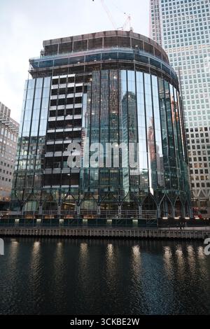 Ein Glasgebäude steht hoch in der Kanarischen Werft an der Themse in London. Stockfoto