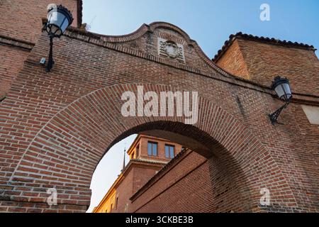 Backsteinbogen, bekannt als Arco de San Bernardo in Alcalá de Henares, Spanien, unterstreicht die handwerkliche und verwitterte Textur Stockfoto