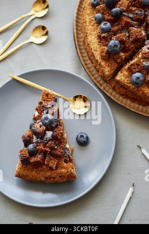 Ein Stück Blueberry Crumble Cake mit frischen Beeren auf Teller Stockfoto