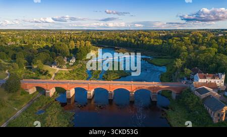 Aus der Vogelperspektive auf die Backsteinbrücke neben Venta Rapid (Ventas rumba), dem breitesten Wasserfall Europas in Kuldīga, einer Stadt am Flussufer in Courlan Stockfoto