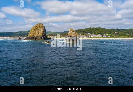Luftaufnahme der Wellen, die am Haystack Rock entlang der Küste Oregons am Cannon Beach abstürzen. Stockfoto