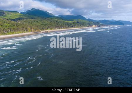 Aus der Vogelperspektive der Wellen, die entlang der Küste Oregons am Cannon Beach entlang des Pacific Coast Highway auf die Felsen stürzen. Stockfoto