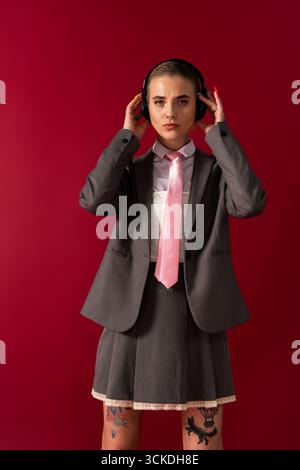 Die schöne junge Frau in einem maßgeschneiderten Anzug zeigt selbstbewusst ihren einzigartigen Stil und ihre Kreativität. Stockfoto