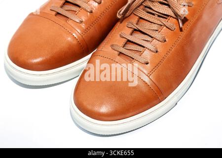 Braune Herrenschuhe aus Leder mit weißer Sohle isoliert auf weißem Hintergrund, Nahaufnahme Stockfoto