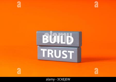 Build Trust auf grauen Holzblöcken geschrieben. Ein Symbol des Vertrauens in Leben und Geschäft. Konzeptionelle Wörter. Pflege von Beziehungen und guter Zusammenarbeit. B Stockfoto