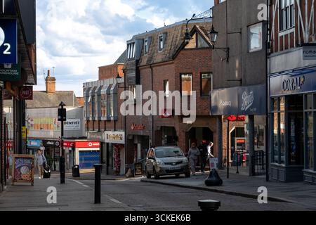 Die High Street in Bishops Stortford, Hertfordshire, Großbritannien, zeigt Geschäfte und Menschen, die an einem sonnigen Tag auf dem Bürgersteig spazieren gehen. Stockfoto