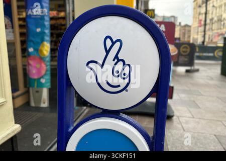Nationales Lotteriezeichen vor einem Tesco Express in Cardiff, Wales, Großbritannien. April 2025. Stockfoto