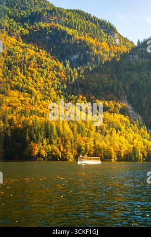 Das Boot fährt am Königssee vorbei, mit wunderschönen Herbstfarben rund um die Uhr. Stockfoto