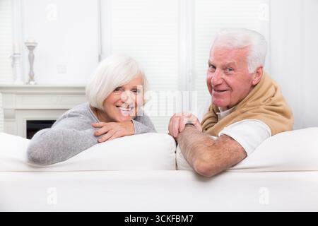 Seniorenpaar, das zu Hause auf dem Sofa chillt Stockfoto