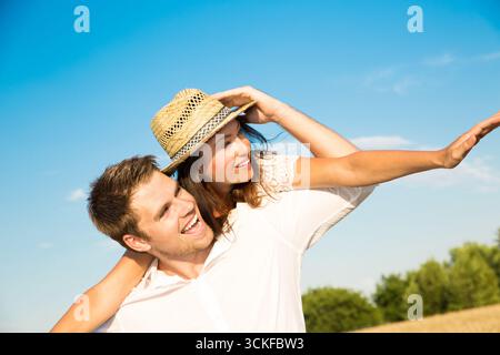 Fröhlicher junger Mann mit seiner blonden Freundin in der Natur Stockfoto