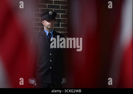 New York, USA. September 2025. Während der Gedenkfeier 9/11 außerhalb des Ground Zero, die anlässlich des 24. Jahrestages der Terroranschläge auf das World Trade Center, das Pentagon und des Absturzes des United Airlines Fluges 93 in Shanksville, PA, am 11. September 2025 in Lower Manhattan, New York City, NY, USA stattfand, steht ein FDNY-Offizier neben der FDNY Memorial Wall. (Foto: Anthony Behar/SIPA USA) Credit: SIPA USA/Alamy Live News Stockfoto