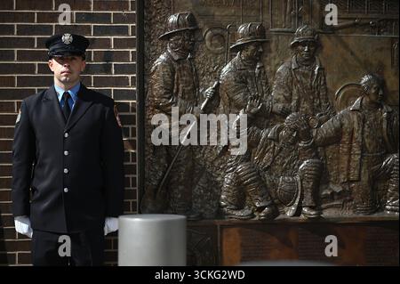 New York, USA. September 2025. Während der Gedenkfeier 9/11 außerhalb des Ground Zero, die anlässlich des 24. Jahrestages der Terroranschläge auf das World Trade Center, das Pentagon und des Absturzes des United Airlines Fluges 93 in Shanksville, PA, am 11. September 2025 in Lower Manhattan, New York City, NY, USA stattfand, steht ein FDNY-Offizier neben der FDNY Memorial Wall. (Foto: Anthony Behar/SIPA USA) Credit: SIPA USA/Alamy Live News Stockfoto