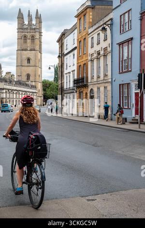 Oxford, Großbritannien, 09. Juli 2025 Blick auf den Magdalen College Tower mit einer jungen Radfahrerin, die Fahrrad fährt Stockfoto