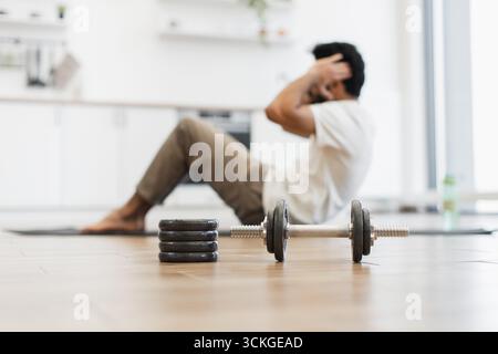 Mann, der Sit-up-Übungen mit Schwerpunkt auf Fitnessgeräten durchführt Stockfoto