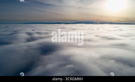Der Himmel ist voller Wolken und die Sonne scheint durch sie Stockfoto