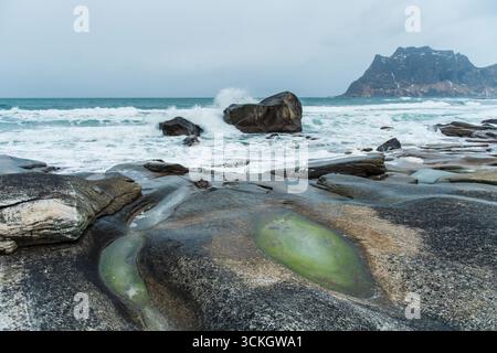 Felsige Küstenlandschaft mit Wellen, die an der Küste krachen. Lofoten-Inseln, Norwegen Stockfoto