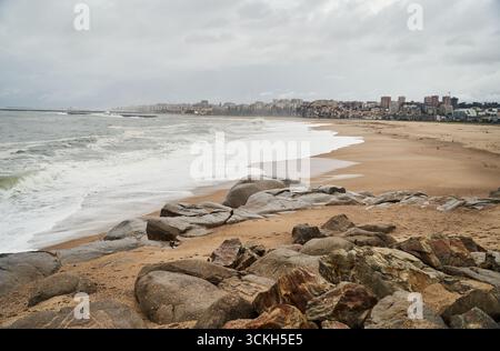 Eine ruhige und friedliche Küstenszene mit einem felsigen Ufer mit sanften Meereswellen, die sanft zusammenbrechen Stockfoto