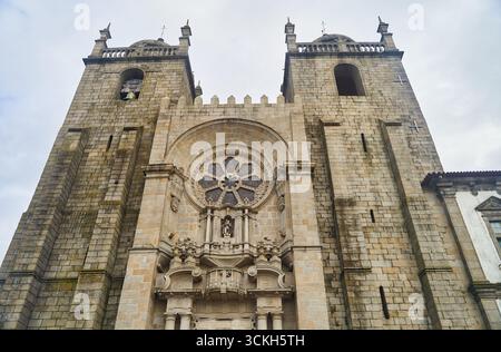 Porto, Portugal - 12.25.2022: Eine historische Kathedrale mit einer atemberaubenden Fassade und großen Steintreppen zum Eingang Stockfoto