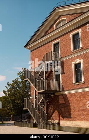 Treppenaufgang an einem historischen roten Backsteingebäude unter blauem Himmel Stockfoto