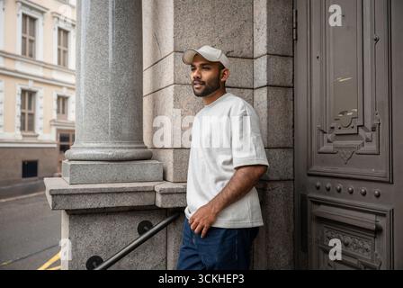 Selbstbewusster Sri-lankischer Mann in Jacke, der in der Helsinki Street posiert Stockfoto