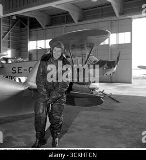 Birgit Thüring: Schwedische Pilotin. Auf diesem Bild von 1958 steht Birgit Thüring (1912–1984) in ihrem Fluganzug in einem Flugzeughangar. Als Zielpilotin, schleppte sie Banner für die Kampfkunst der Luftwaffe und demonstrierte Präzision und Mut in einer kritischen Rolle. Birgits Präsenz auf Gotlands abgelegenem Luftwaffenstützpunkt spiegelt Schwedens erste Schritte hin zur Gleichstellung der Geschlechter in der Militärluftfahrt wider. Conard Ref. 3684 Stockfoto