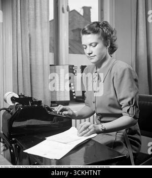 Junge Frau bei der Arbeit: Berechnen an ihrem Schreibtisch, 1942. Eine Angestellte sitzt und zählt auf einen Taschenrechner. Kristoffersson Ref. A117-4 Stockfoto