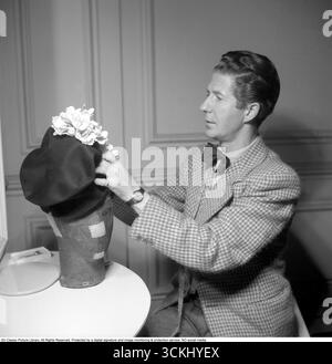 Aage Thaarup (1906–1987) war ein bekannter dänischer Müller mit Sitz in London, der für die Entwicklung eleganter und innovativer Hüte für die hohe Gesellschaft und das Königtum, einschließlich Königin Elizabeth II., berühmt wurde. Seine luxuriösen Kreationen, die oft mit mutigen Formen und komplizierten Details versehen waren, prägten die Mode der Mitte des 20. Jahrhunderts und erlangten ihm internationale Anerkennung. 1945. Kristoffersson Ref. S151-3 Stockfoto