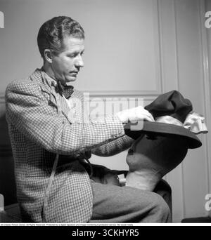 Aage Thaarup (1906–1987) war ein bekannter dänischer Müller mit Sitz in London, der für die Entwicklung eleganter und innovativer Hüte für die hohe Gesellschaft und das Königtum, einschließlich Königin Elizabeth II., berühmt wurde. Seine luxuriösen Kreationen, die oft mit mutigen Formen und komplizierten Details versehen waren, prägten die Mode der Mitte des 20. Jahrhunderts und erlangten ihm internationale Anerkennung. 1945. Kristoffersson Ref. S152-2 Stockfoto
