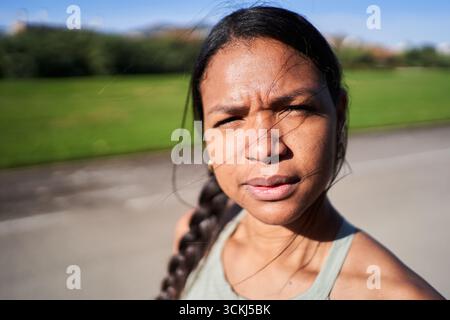 Nahporträt einer afrikanischen Millennialfrau in Sportbekleidung im Freien mit ernstem Ausdruck Stockfoto