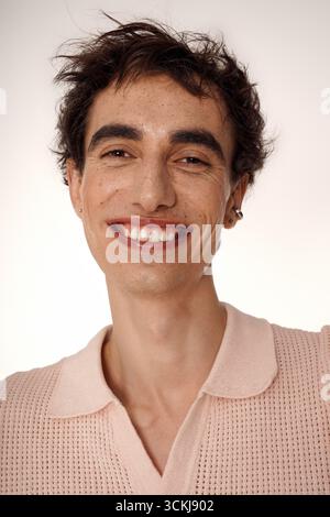 Hübsche Individualität in stilvoller Kleidung, die Selbstvertrauen und Charme in einer hellen Umgebung ausstrahlt. Stockfoto