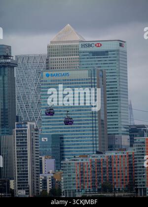 Die IFS Cloud Cable Car passiert einen Canada Square, auch bekannt als Canary Wharf Tower (spitzes Dach), mit HSBC und Barclays Wolkenkratzern im Vordergrund, London, Großbritannien Stockfoto