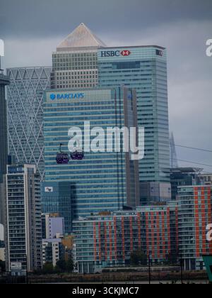 Die IFS Cloud Cable Car passiert einen Canada Square, auch bekannt als Canary Wharf Tower (spitzes Dach), mit HSBC und Barclays Wolkenkratzern im Vordergrund, London, Großbritannien Stockfoto