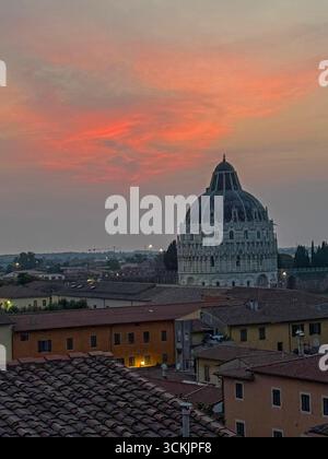 In der Abenddämmerung über dem Wahrzeichen des Baptisteriums auf der Piazza del Duomo in Pisa in der Toskana in Italien. Stockfoto