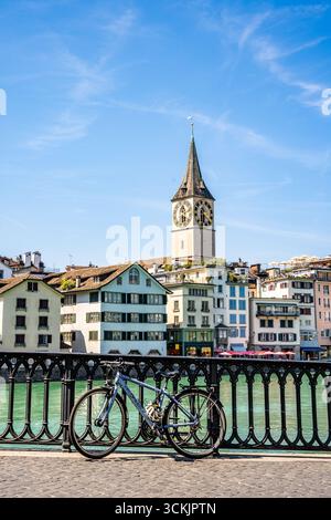 Malerischer Blick auf die Limmat von der Münsterhofbrücke mit Fahrrad und Peterskirche im Hintergrund, in der Züricher Altstadt, Schweiz Stockfoto