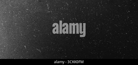 Dunkler, zerkratzter Hintergrund mit Grunge-Textur. Schwarzer Vintage-Hintergrund mit Staub und Kratzern Stockfoto