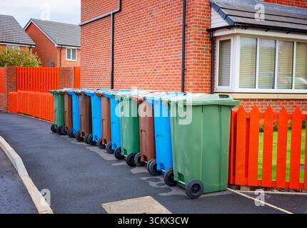 Eine Reihe grüner, brauner und blauer Mülltonnen, bereit zur Abholung vor einem Haus in Blackpool, Lancashire, Großbritannien Stockfoto