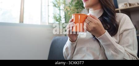 Wellness. Eine junge Frau genießt zu Hause ein warmes Getränk. Stockfoto