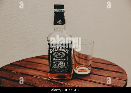Kiew, Ukraine 7 Mai 2024 Jack Daniels Whiskey mit leerem Glas auf einem Holztisch Tennessee Whiskey sitzt auf einem rustikalen, dunklen Holztisch. Stockfoto