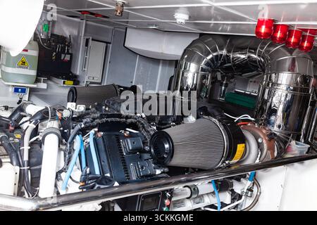 Im Maschinenraum der Luxusyacht befindet sich ein brandneuer Schiffsmotor mit einem Alarm an der Decke. Stockfoto